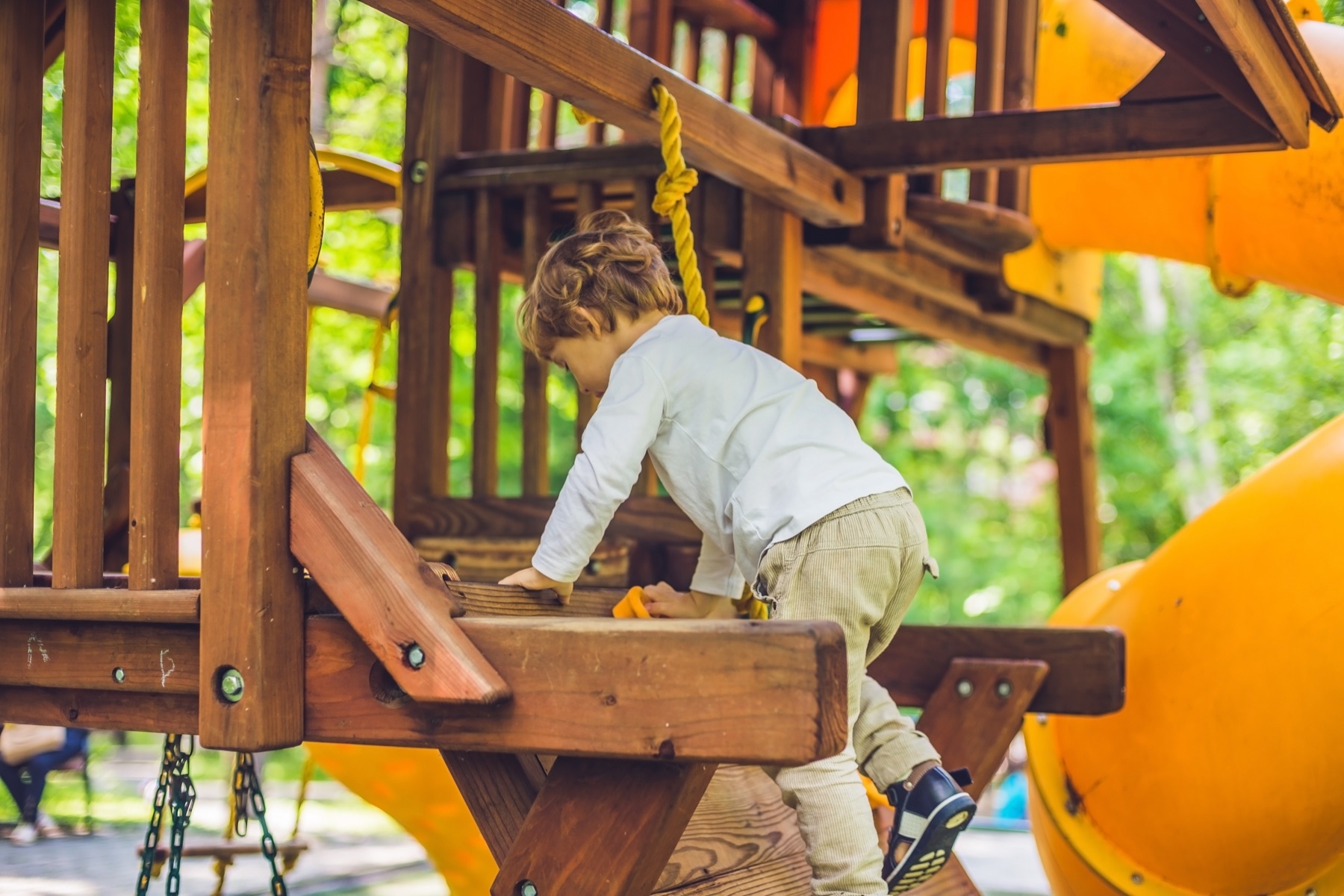 A child climbing a timber play fort