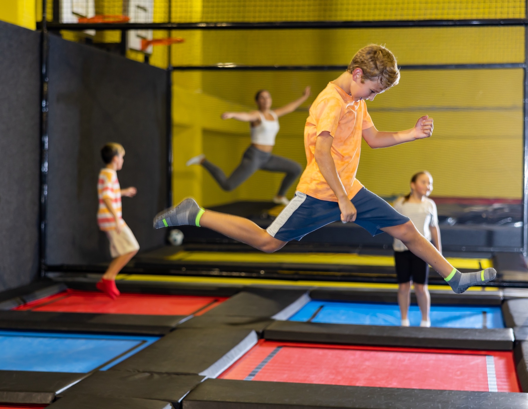 A boy jumping across trampolines