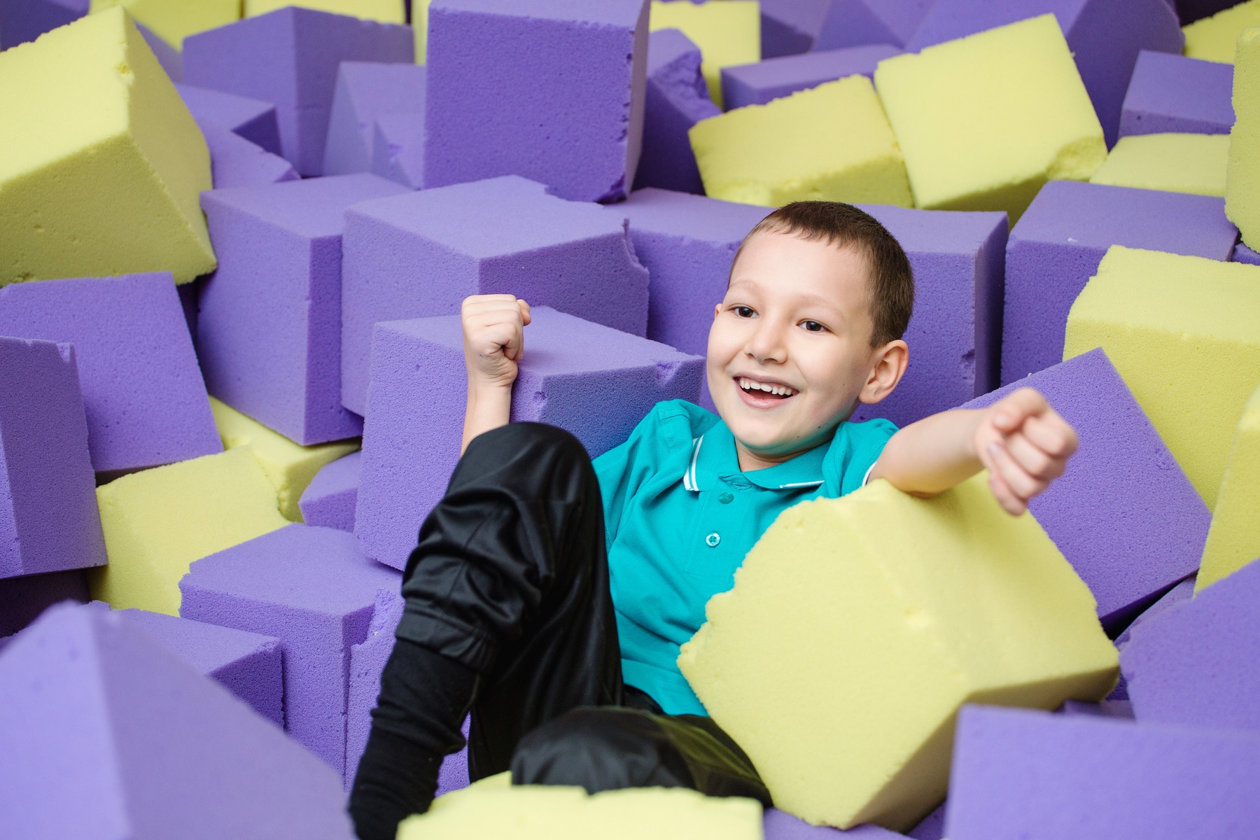 A child landing in a pit of foam blocks