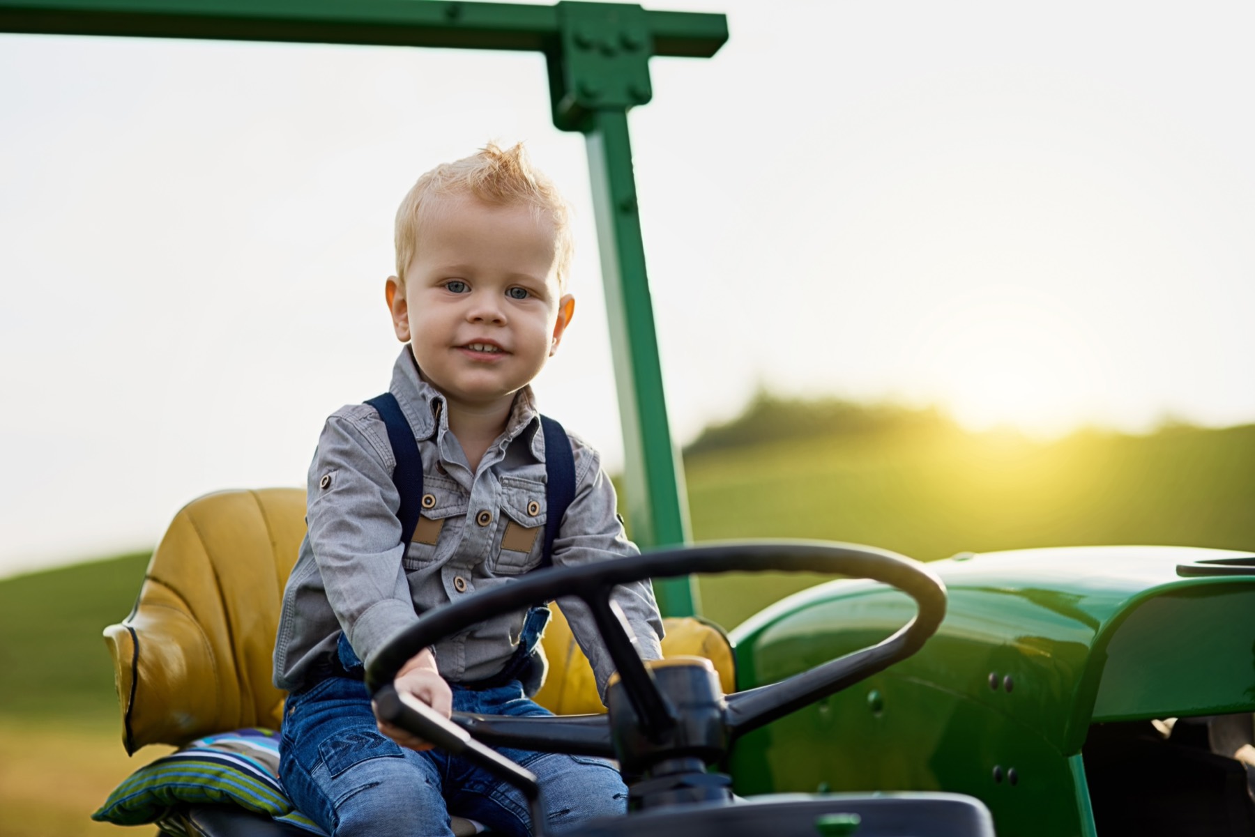 A small boy at the wheel of a tractor
